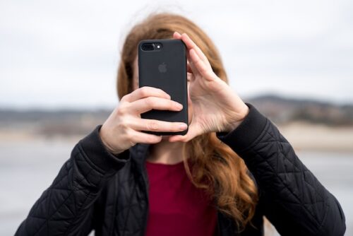 woman holding phone in front of face