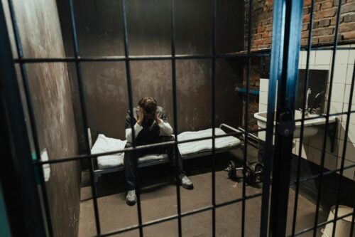 man sitting in jail cell